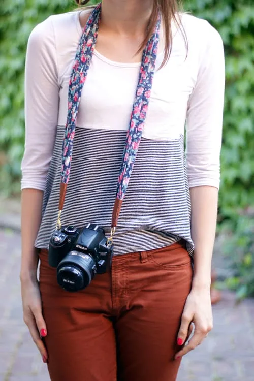 Woman wearing camera hanging from a fabric strap
