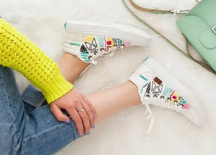 seated woman wearing embroidered sneakers