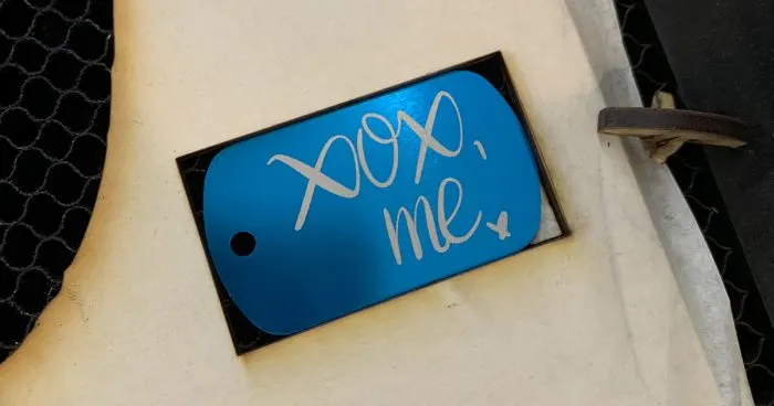 metal tag engraved with xoxo, me