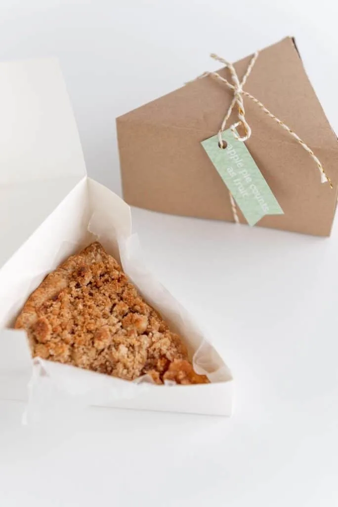 pie slice box tied with a string and hanging gift tag. A second box with a piece of pie in the box