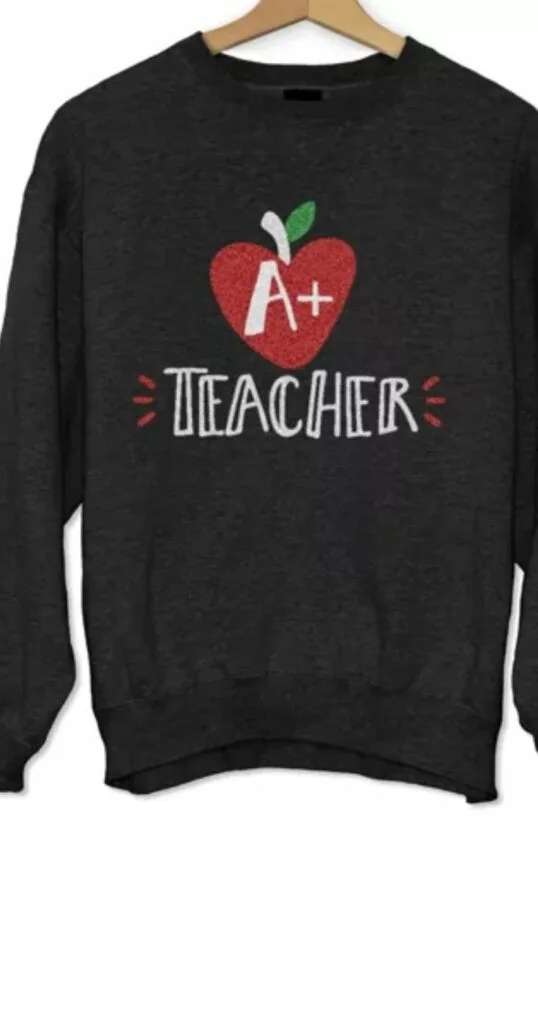 sweatshirt on a hanger with a drawing of an apple and the words A+ teacher