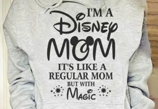 woman wearing a sweatshirt with the words I'm a Disney mom