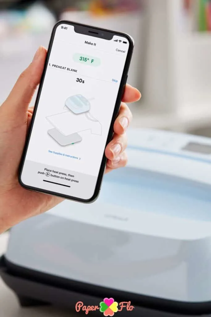 hand holding a mobile phone opened to the Criuct app. The temperature settings for a Cricut press are shown in the app.
