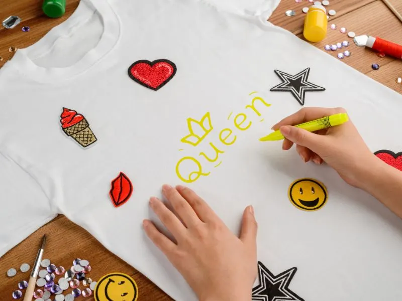 person holding a marker to customize a t-shirt
