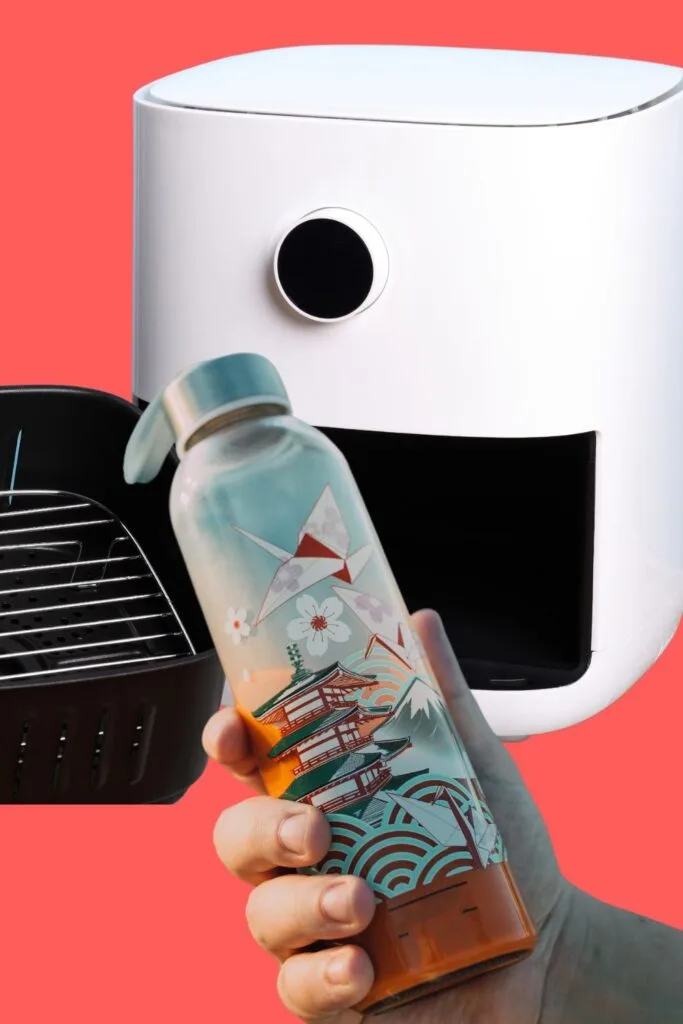 white air fryer with hand holding a decorated tumbler