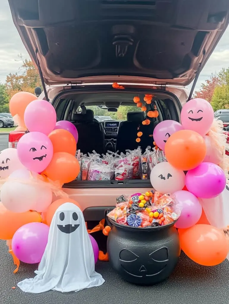 Pink balloons, candy and ghosts in a car trunk.