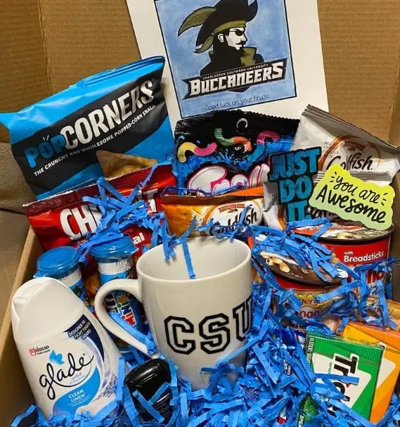 a box full of personal care items and snacks in the school colors of the Charles Southern University Buccaneers.