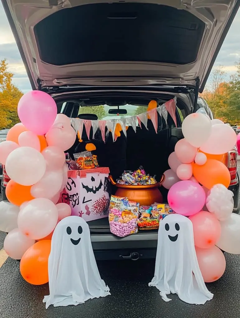 Pink balloons, candy and ghosts in a car trunk.