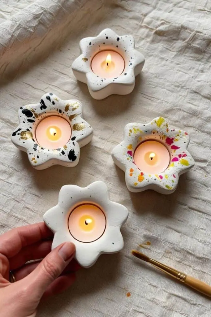 Make your own flower-shaped tealight holders using air dry clay. Add colorful paint splatters for a playful, modern twist that makes each piece totally unique.