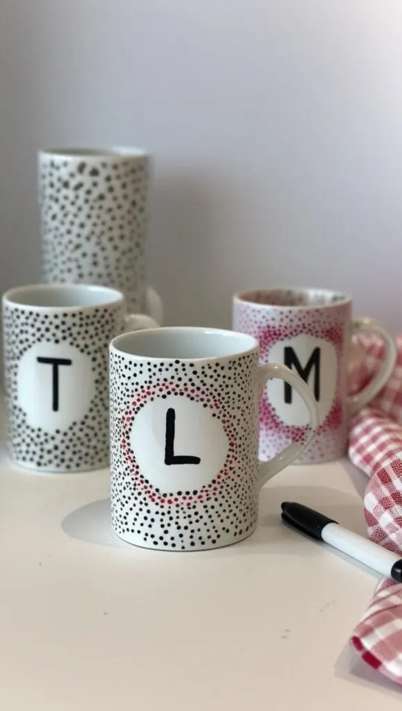 Try your hand at these modern DIY dot mugs made with Sharpies and ceramic Dollar Tree blanks. These monogram mugs make excellent gifts for coworkers, teachers, or friends. Simple to design and bake for permanence—this project is perfect for beginners who want a custom creation with a sleek, minimalist style.
