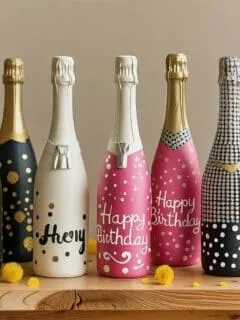 Celebrate in style with these painted bottle centerpieces, perfect for birthdays, milestone parties, and festive gatherings. Each champagne bottle is hand-painted with unique designs, from glittery “18” and chic tuxedo patterns to cheerful “Happy Birthday” messages. These DIY party bottles make eye-catching decorations and personalized gifts, adding a fun, creative touch to any celebration.