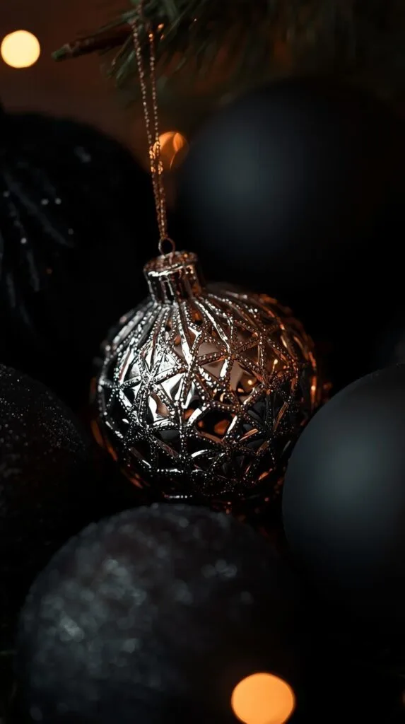 Get inspired by this elegant ornament detail—perfect for a moody Christmas tree or glam black Christmas decor. The filigree silver sphere pops beautifully against matte black ornaments and warm twinkle lights. A great example of how mixing textures brings depth to a modern Christmas tree. Try pairing metallic patterns with smooth matte ornaments for a luxe holiday look.